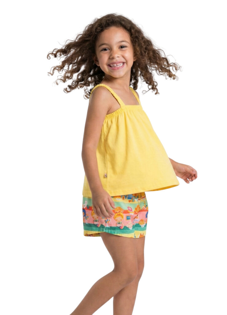 menina sorridente com conjunto composto por regata amarela e short estampado, que fazem parte da coleção Alphabeto Todo Dia. 